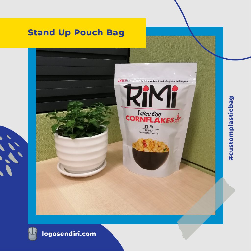A white stand-up pouch of RiMi Salted Egg Cornflakes sitting on a wooden desk next to a small potted plant.
