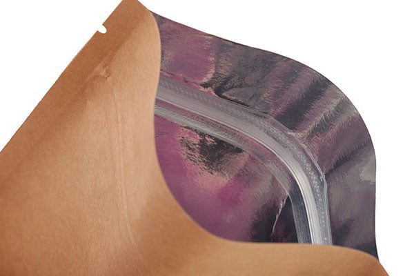 An open brown kraft paper pouch with a clear plastic zipper seal and a purple interior lining.
