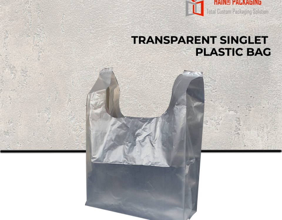 A clear, thin plastic singlet-style shopping bag standing upright against a textured grey background.