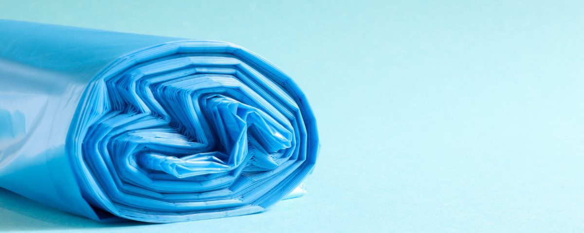 A roll of blue plastic bags on a light blue background.