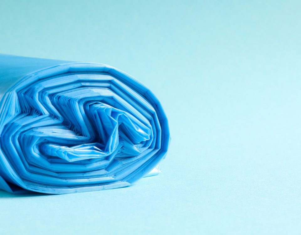 A roll of blue plastic bags on a light blue background.