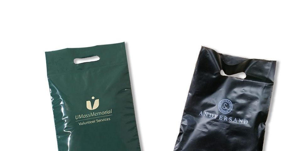 Two plastic shopping bags with die-cut handles, one dark green and one black, displayed against a white background.