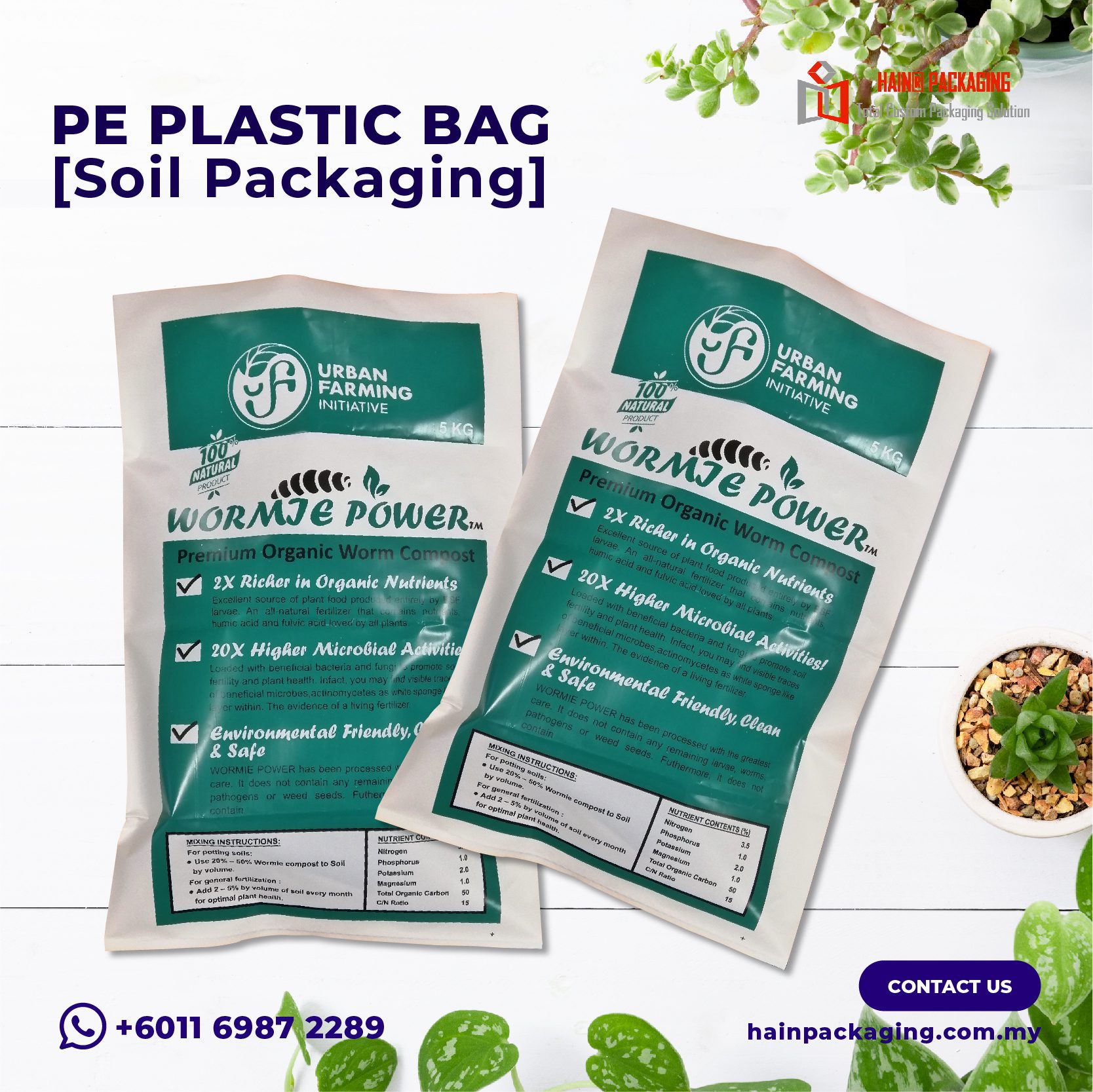Two white and green plastic bags labeled Wormie Power, displayed on a white wooden surface with small potted plants.