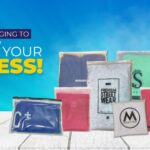 A collection of various branded plastic and paper mailing bags arranged on a white wooden surface against a blue background with promotional text.