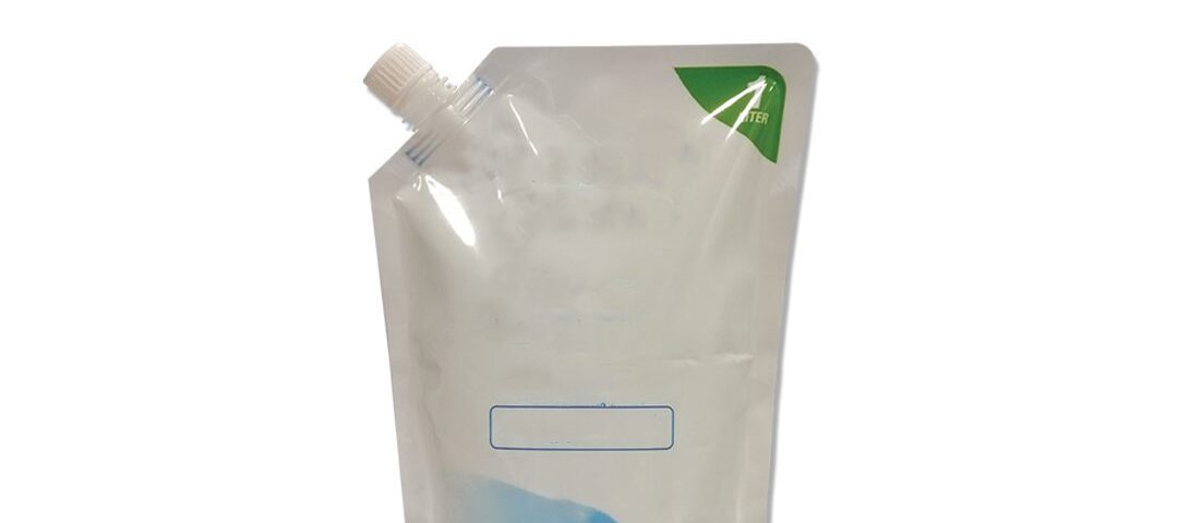 A clear stand-up pouch with a white plastic spout, featuring a blue graphic at the bottom and a green triangle in the top corner.