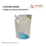 A clear stand-up pouch with a white plastic spout, featuring a blue graphic at the bottom and a green triangle in the top corner.