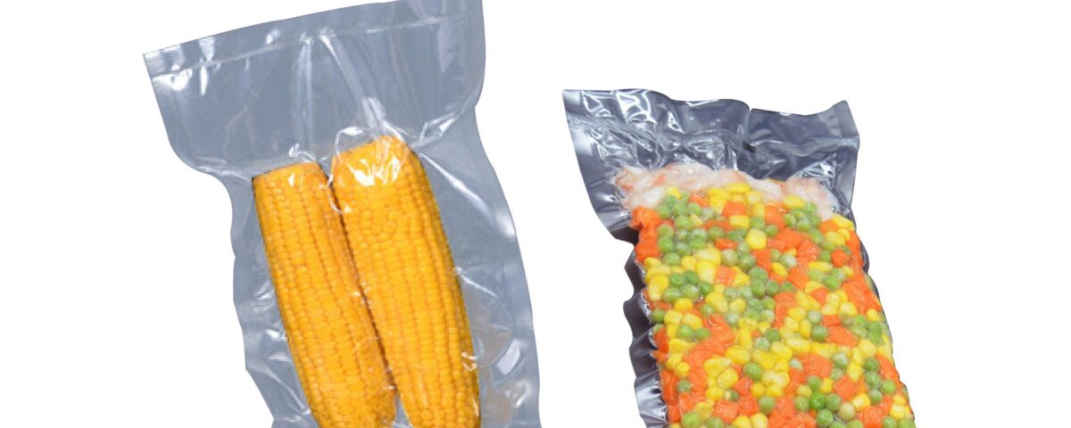 Two clear vacuum-sealed plastic bags, one containing two ears of corn and the other containing a mix of frozen vegetables.
