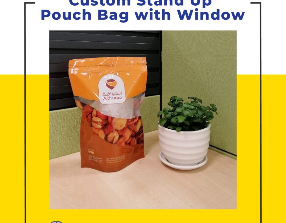 A stand-up pouch with a clear window containing dried fruit sits next to a small green plant in a white pot on a desk.