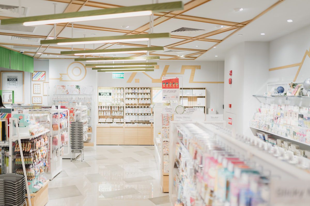 Interior view of a brightly lit retail store with shelves stocked with various products.